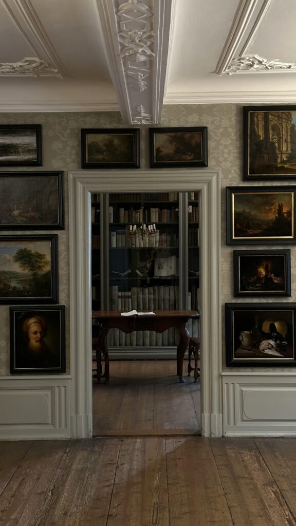 A classy home interior showcasing antique paintings and an elegant hallway.